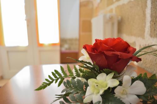 a vase with red roses and white flowers on a table at Borgo Saraceno in Spinazzola