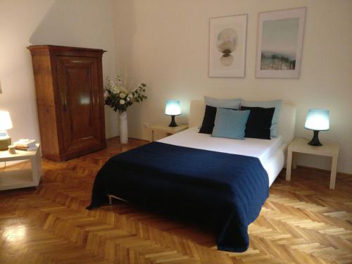 ブダペストにあるOpera Dream Apartmentのベッドルーム1室(大型ベッド1台、ランプ2つ付)