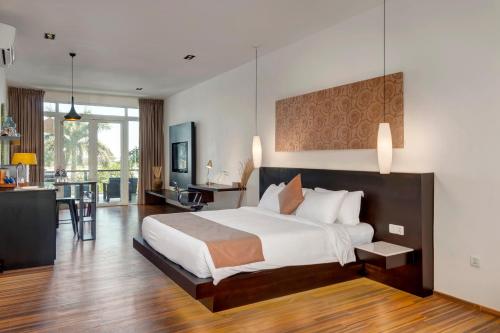 a large bedroom with a large bed and a kitchen at TAO Riverside Residence in Phnom Penh