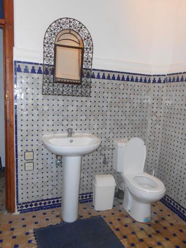 a bathroom with a sink and a toilet and a mirror at Petit Bijou de Tanger in Tangier