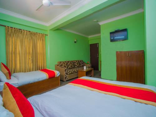 a green room with two beds and a television at Waling Fulbari Guest House in Bālāju