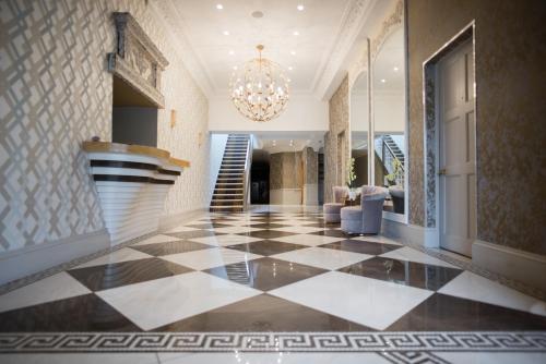 a lobby with a checkered floor and a chandelier at Guildford Manor Hotel & Spa in Guildford