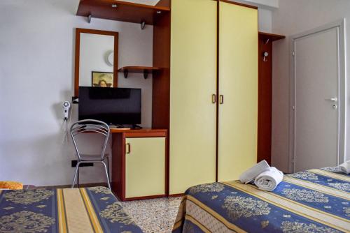een hotelkamer met 2 bedden en een televisie bij Hotel Dear Rimini in Rimini