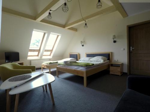 a bedroom with a bed and a couch and a table at Galicówka in Poronin