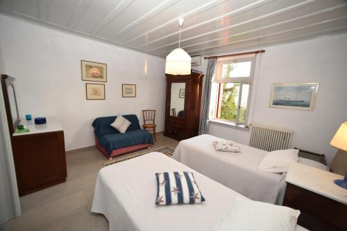 Habitación con 2 camas y silla azul en Molyvos Manor, en Mithimna