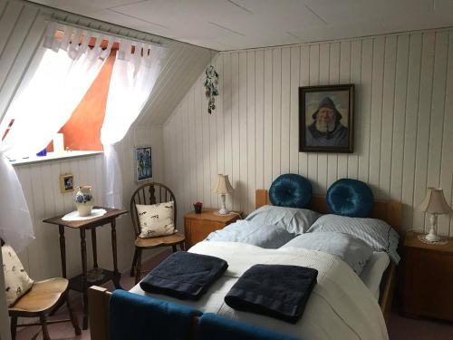 Un dormitorio con una cama con almohadas azules. en Løkken Farm Holiday en Løkken