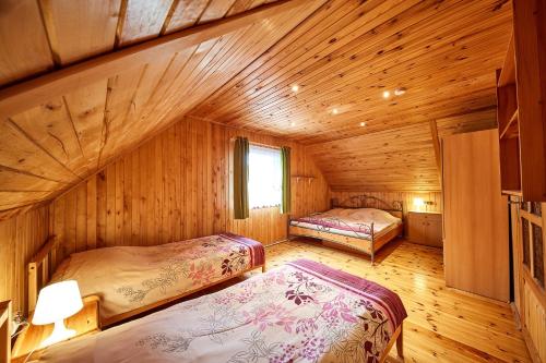 una camera con due letti in una baita di legno di Domki Letniskowe Jerutki a Świętajno