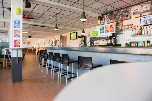 um bar com uma fila de cadeiras num restaurante em CAMPING BONNE ANSE PLAGE em La Palmyre