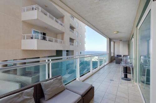 an apartment balcony with a couch and a view of the ocean at Luxury Apt with side Seaviews and Pool, Best Location by Buena Vista in Sliema