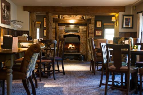 a restaurant with a fireplace and tables and chairs at The Foxglove by Innkeeper's Collection in Kirkburton