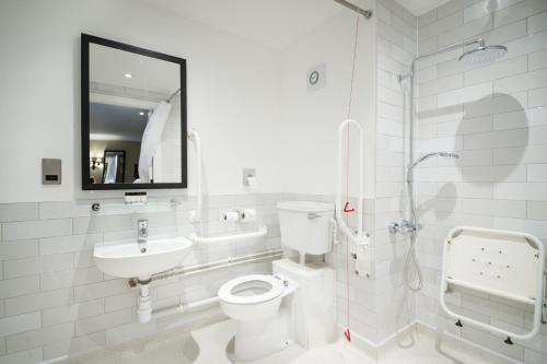 a white bathroom with a toilet and a sink at The Foxglove by Innkeeper's Collection in Kirkburton