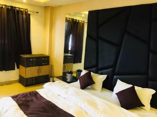 a bedroom with a large bed with a black headboard at Hotel Khalsa -Lake View in Pachmarhī