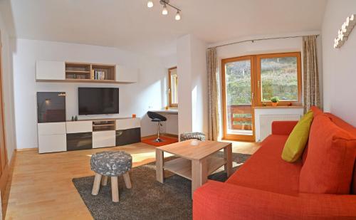 a living room with a red couch and a table at Apartments Weißstein in Gries im Sellrain