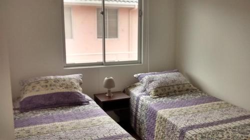 two beds sitting next to each other in a bedroom at Dpto La Serena in La Serena