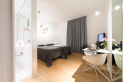 a bedroom with a bed and a desk with a computer at Hotel Colle Del Sole in Alberobello