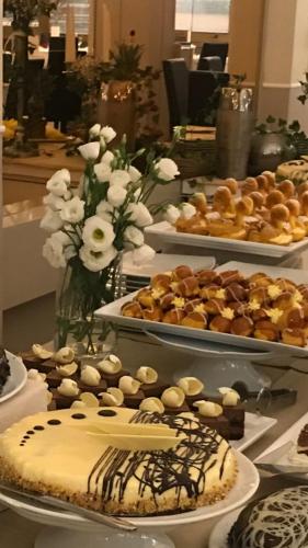 a table topped with cakes and other desserts on plates at Rouge Hotel International in Milano Marittima
