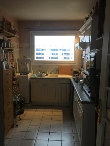 una cocina con fregadero y una ventana. en une chambre ENGHIEN LES BAINS centre gare, en Enghien-les-Bains