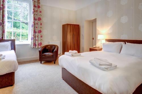 a hotel room with two beds and a chair at Lord Haldon Country Hotel, Sure Hotel Collection by Best Western in Exeter