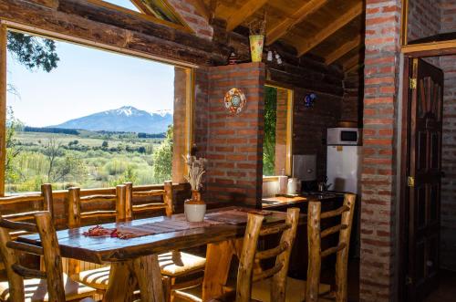 a dining room with a table and a large window at Arroyo Escondido in Trevelin