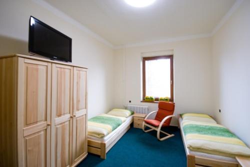 a room with two beds and a flat screen tv at Penzion Svet in Třinec
