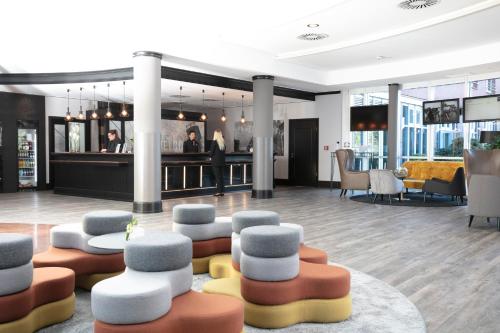 a lobby with couches and chairs and a bar at Dorint An den Westfalenhallen Dortmund in Dortmund