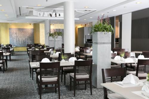 a dining room filled with tables and chairs at Dorint An den Westfalenhallen Dortmund in Dortmund
