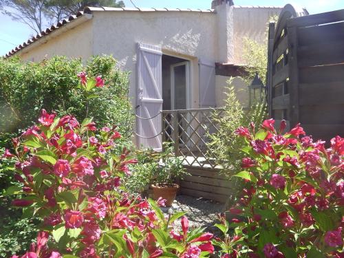 a garden with pink flowers in front of a house at la souquette in Draguignan