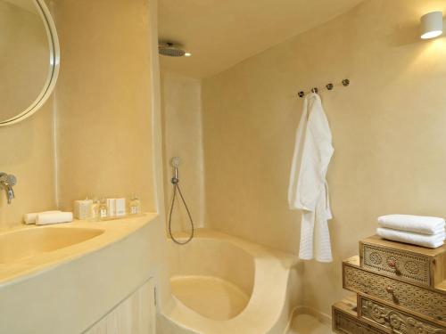 a bathroom with a sink and a toilet and a mirror at Astra Suites in Imerovigli