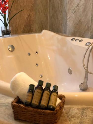 a basket of wine bottles sitting next to a bath tub at MAJU HOTEL CAMPESTRE & SPA in Jamapa