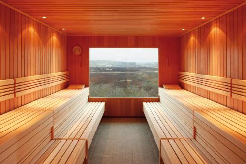 a room with wooden benches and a large window at Hapimag Ferienwohnungen Hörnum in Hörnum
