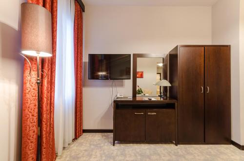 a room with a dresser and a mirror at Hotel Aurum in Hajdúszoboszló