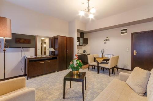 a living room with a couch and a table at Hotel Aurum in Hajdúszoboszló