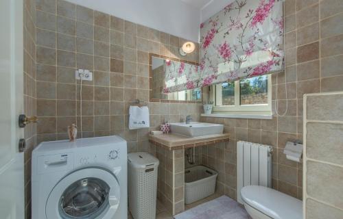 a bathroom with a washing machine and a sink at Villa Sana in Selina