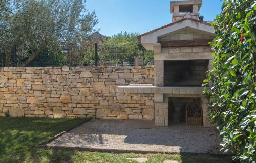 a stone wall with a stone oven in a yard at Villa Sana in Selina