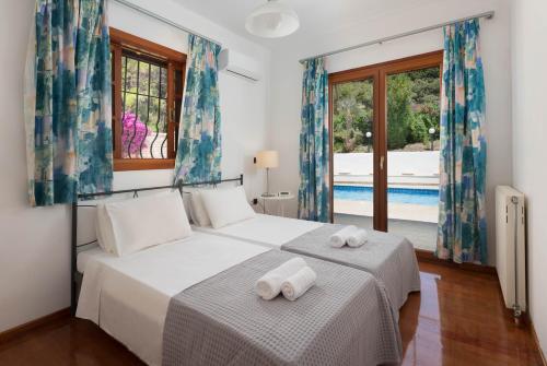 a bedroom with a bed with two towels on it at Una Villa Rhodes in Ixia