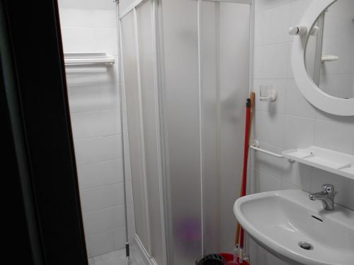 a white bathroom with a sink and a mirror at Le Case Punta Negra in Stintino