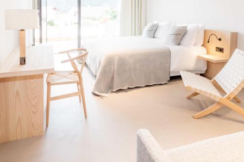a bedroom with a bed and a desk and a chair at Schgaguler Hotel in Castelrotto