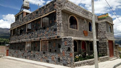 un bâtiment en pierre au coin d'une rue dans l'établissement Los Geranios, à Yanque