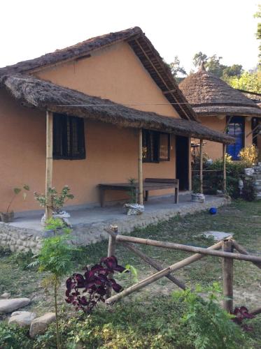 a house with a thatched roof and a fence at My beautiful cottage in pokhara in Pokhara