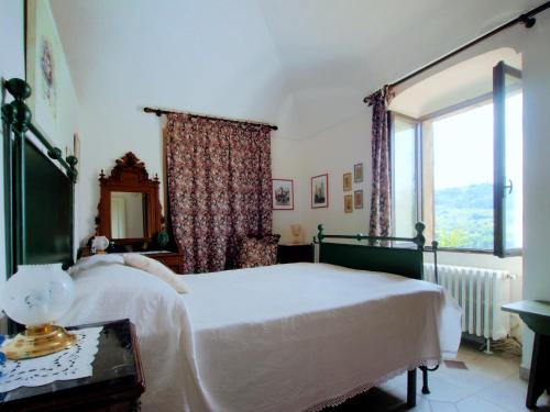 1 dormitorio con cama blanca y ventana en casa ciosse, en Grognardo