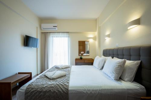 a hotel room with a large bed with white pillows at Gramvoussa Bay in Kissamos