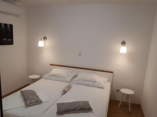 Un dormitorio con una cama blanca con dos almohadas. en Apartment Viki, en Makarska