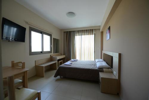 a hotel room with a bed and a television at Crystal Bay Hotel in Kissamos