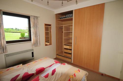 a bedroom with a bed and a large window at Appt. ÄISCHER in Wilwerwiltz