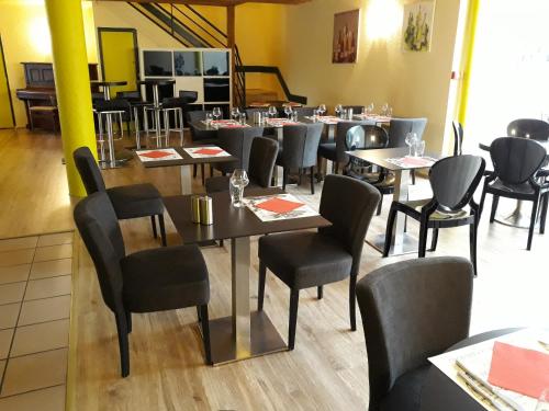 Aux Lys de Chablis في شابلي: صالة طعام المطعم مع طاولات وكراسي