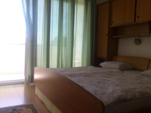 a large bed in a room with a window at MIRKO DIVING CENTER in Rab