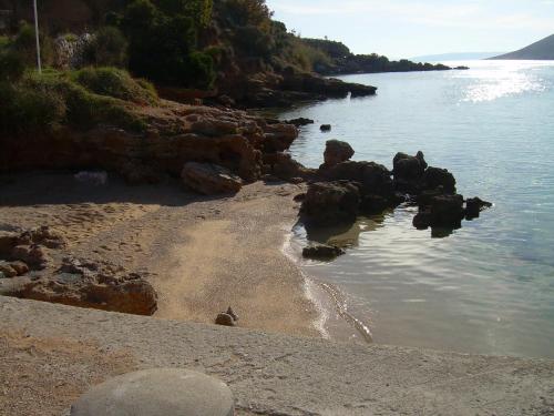 a beach with rocks in the water and the ocean at MIRKO DIVING CENTER in Rab