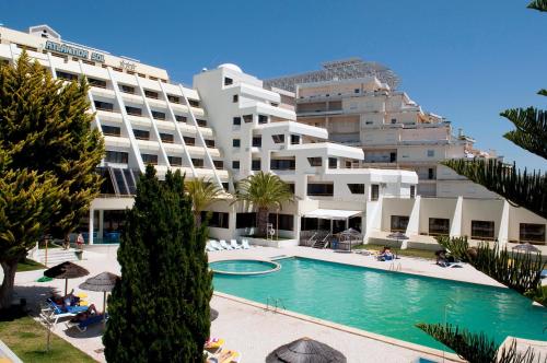 a hotel with a swimming pool in front of a building at Hotel Atlantida Sol in Figueira da Foz