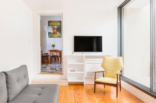 een woonkamer met een bank en een tv bij Patio São Vicente in Lissabon