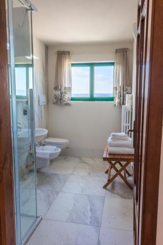 a bathroom with a toilet and a sink and a shower at Villa Pioppi Hotel in Sirmione